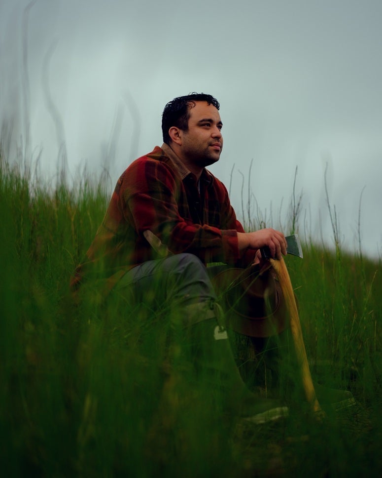 'Alone' Season 11 cast member Isaiah Tuck sitting in the grass