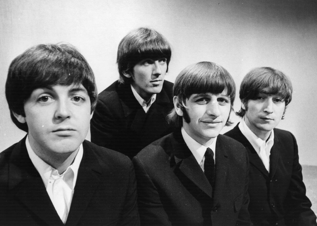 A black and white picture of Paul McCartney, George Harrison, Ringo Starr, and John Lennon of The Beatles posing in suits.