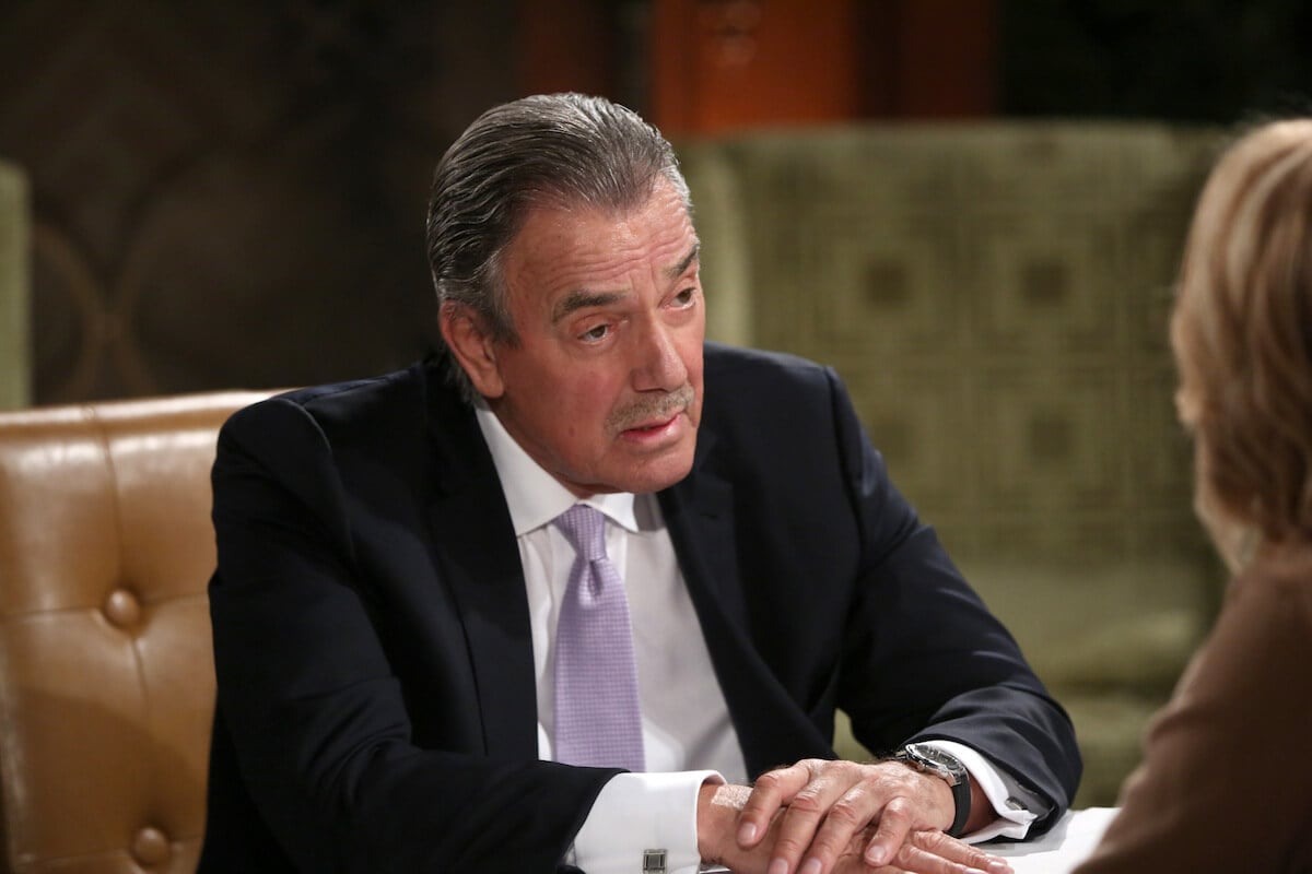 Eric Braeden sitting with one hand over another on a desk