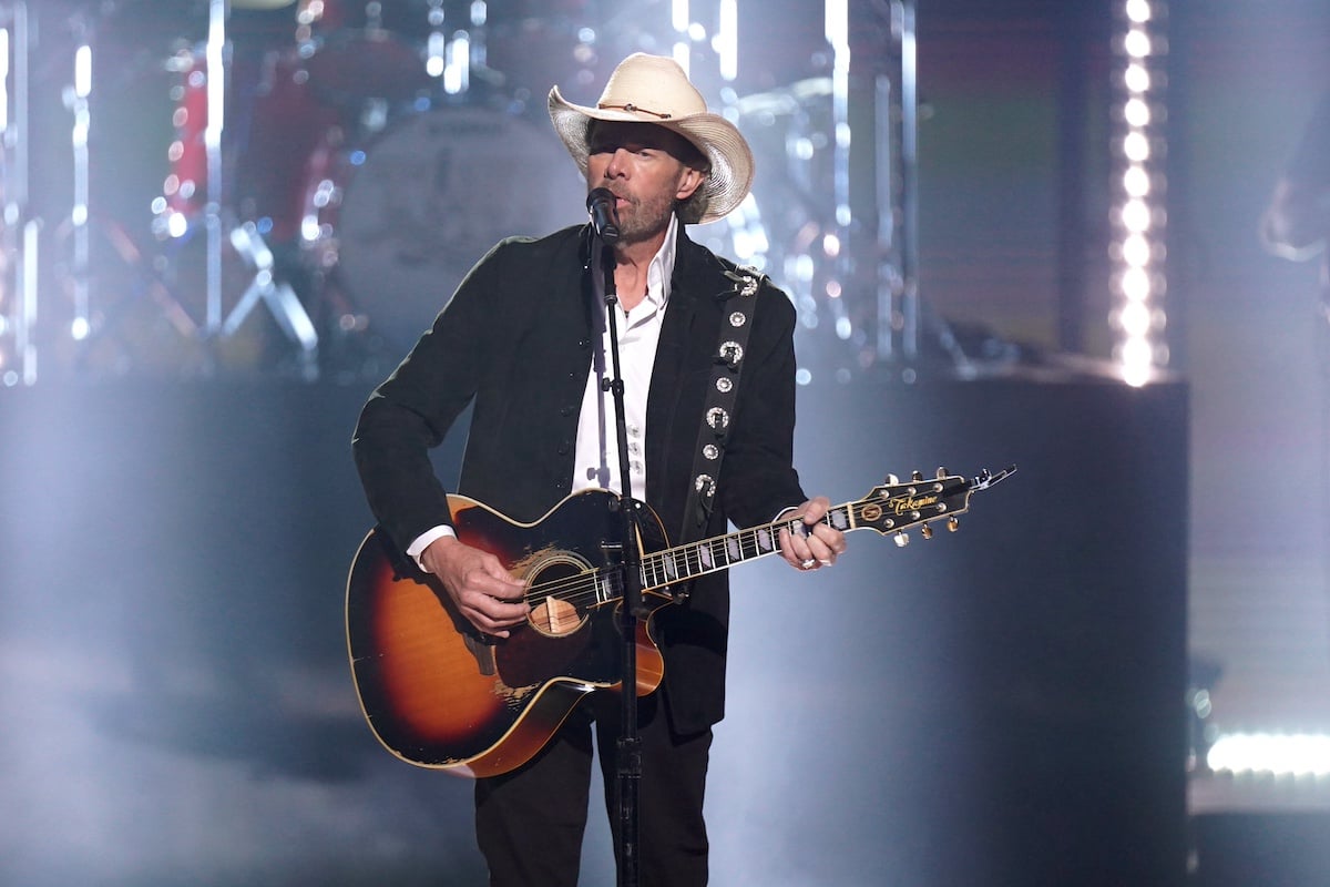 Toby Keith wearing a cowboy hat and playing a guitar