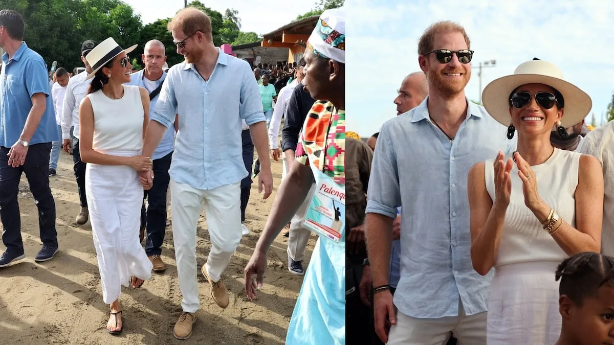 Wearing a white skirt and top, Meghan Markle holds Prince Harry's hand as she smiles in Columbia