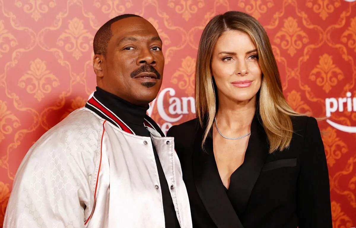 Eddie Murphy and Paige Butcher posing at the premiere of "Candy Cane Lane".