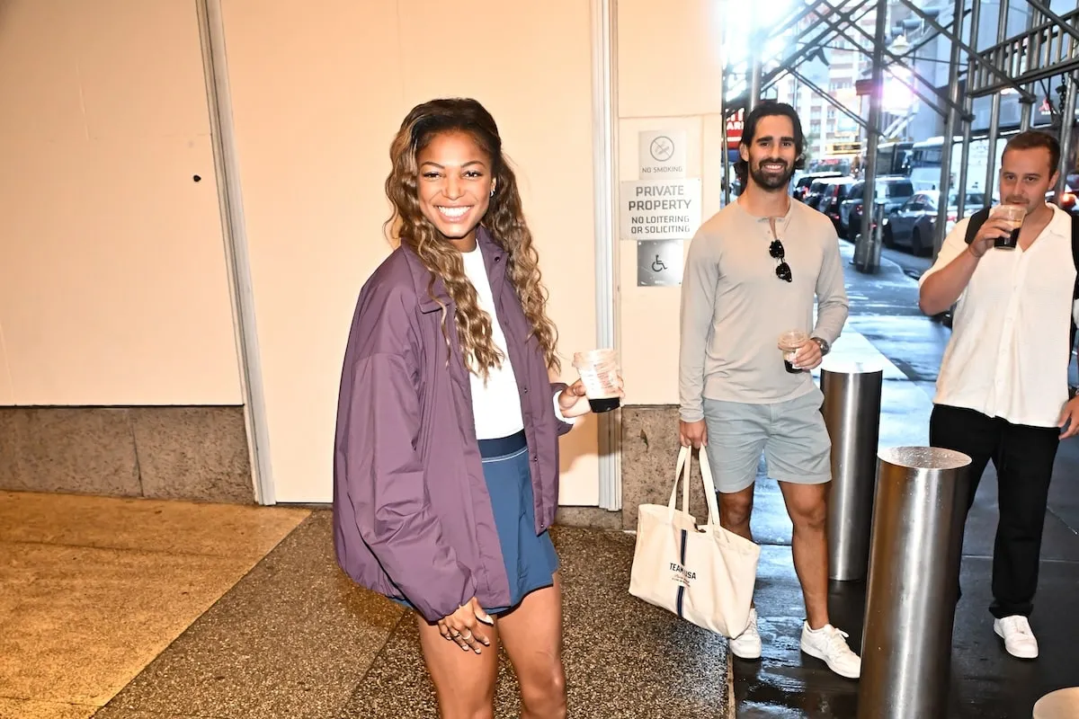 Wearing a purple jacket and navy shorts, Gabby Thomas exits CBS studios in NYC