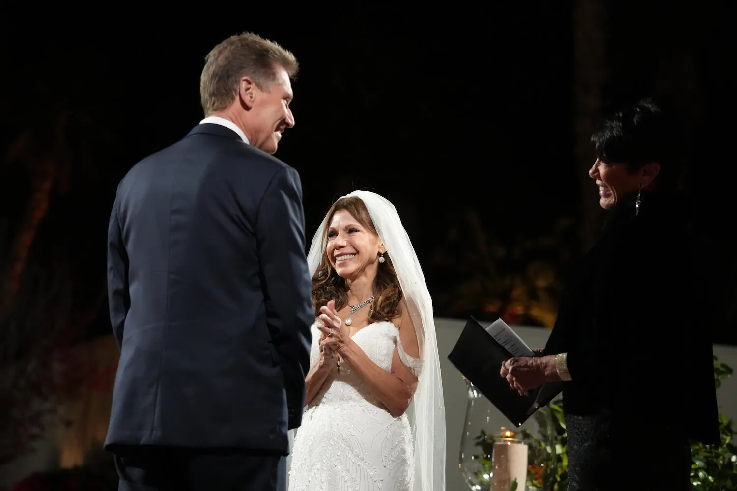 'The Golden Bachelor' star Gerry Turner in a suit on his wedding day in front of Theresa Nist, who's smiling in a wedding dress and veil