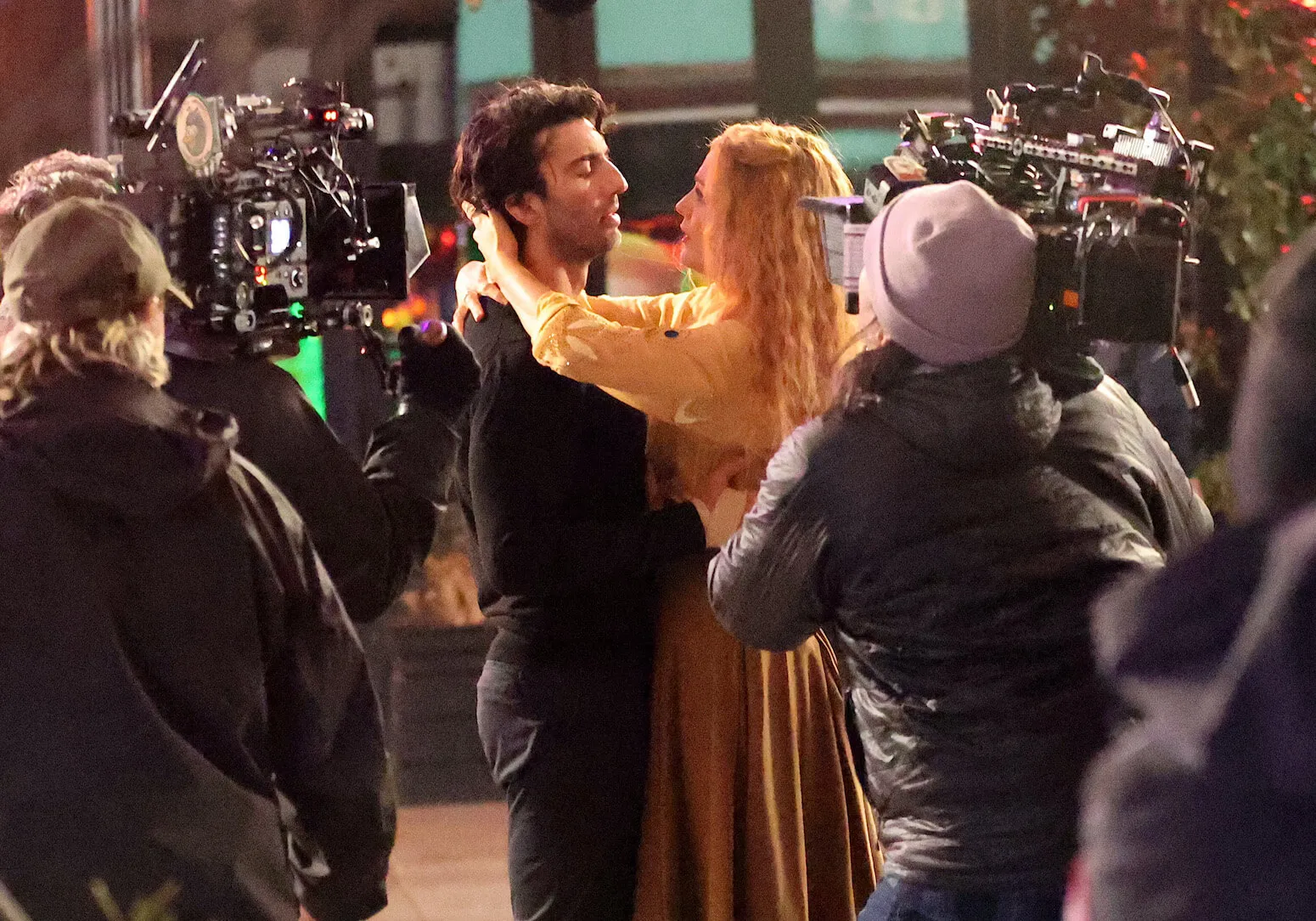 Justin Baldoni and Blake Lively embracing while surrounded by crew members on the set of 'It Ends With Us'