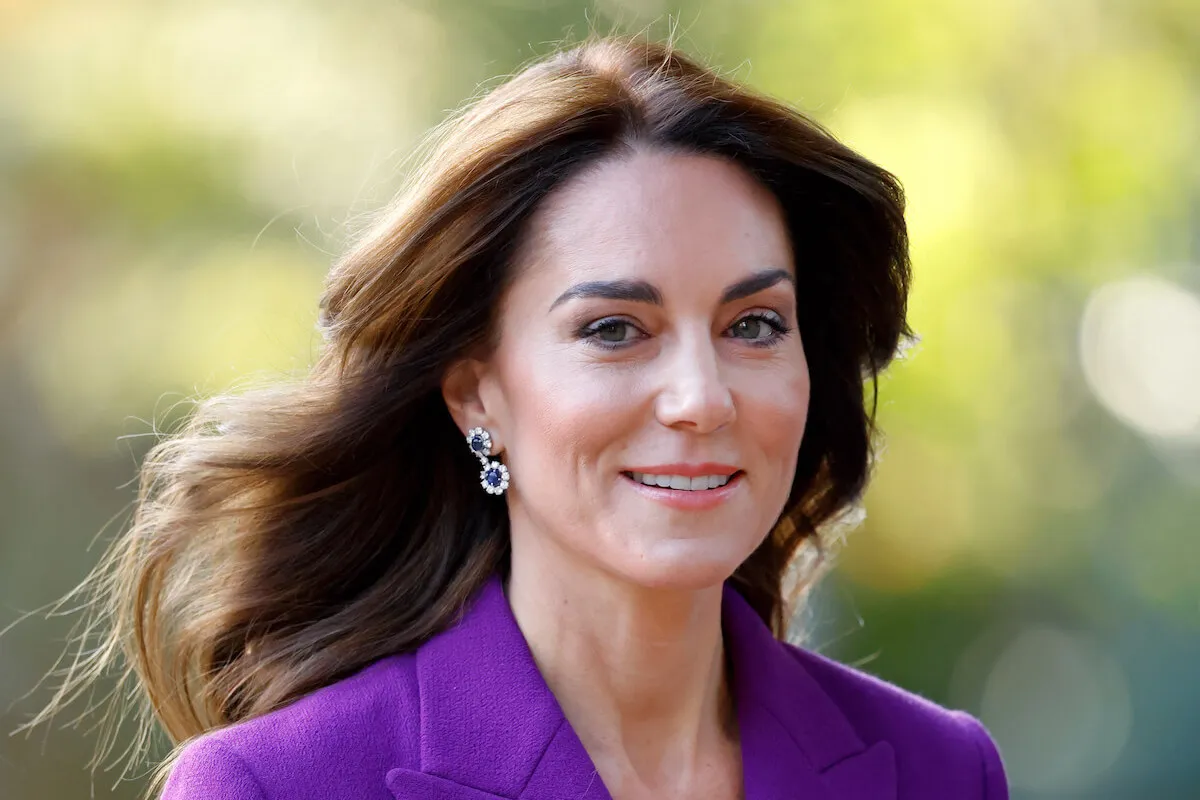 Kate Middleton, who appeared on the cover of British Vogue in 2016, looks on wearing purple.