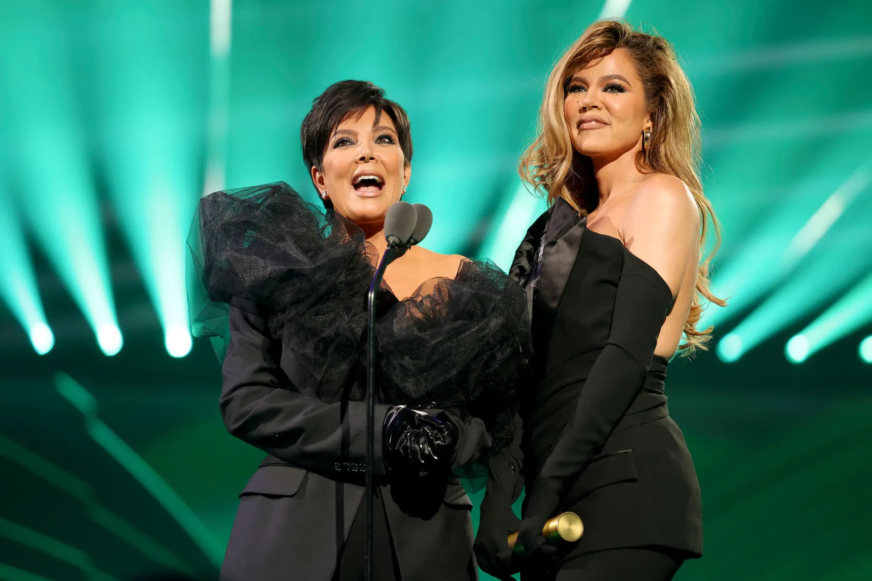 Kris Jenner and Khloé Kardashian wearing black on stage at the 2022 People's Choice Awards while accepting The Reality Show of 2022 award for ‘The Kardashians’