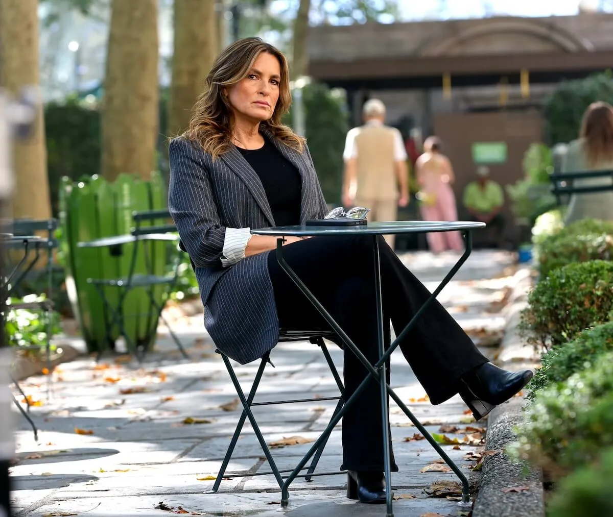 Mariska Hargitay sitting at a cafe table in an NYC park on the set of 'Law & Order: SVU' Season 26