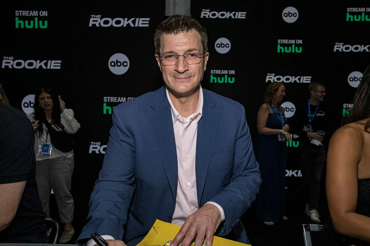 Nathan Fillion signing autographs at Comic Con.